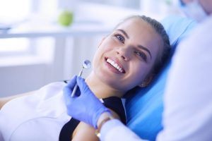 a woman smiles in a dental chair