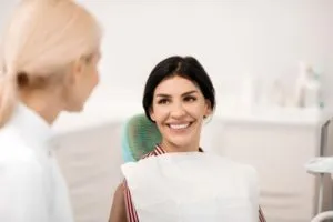 a female patient smiles in dental chair
