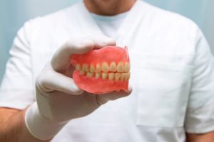 man holds a denture model