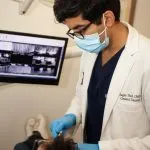 Dr. Shah working on a patient in a dental chair