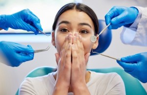 Woman covering mouth scared of th dentist