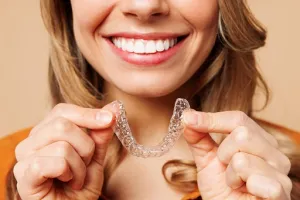 Woman holding Invisalign Tray